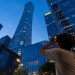 A small plane has crashed into a Beijing high-rise, killing the pilot and injuring 13