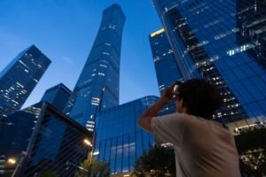 A small plane has crashed into a Beijing high-rise, killing the pilot and injuring 13